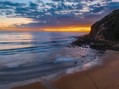 Aerial sunrise seascape with clouds at  Macmasters Beach on the Central Coast, NSW, Australia.