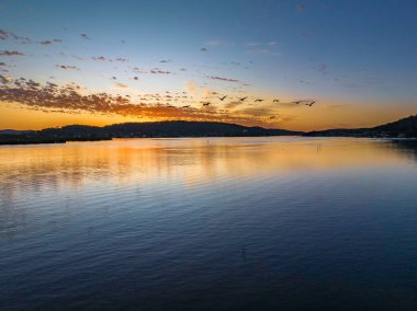 Körfezin üzerinde gökyüzünü boyayan altokümülüs bulutlarıyla birlikte havadan gün doğumu Central Coast, NSW, Avustralya 'da..