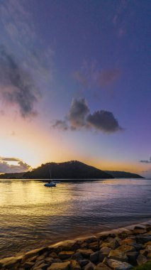 Sunrise over Brisbane Water with clouds and boats at Ettalong Beach on the Central Coast, NSW, Australia.