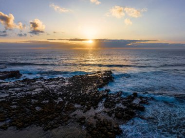 Central Coast, NSW, Avustralya 'daki Kuzey Avoca' da güneş, bulutlar ve kaya platformu ile gün doğumu deniz manzarası.