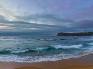 Central Coast, NSW, Avustralya 'daki Copacabana' da serin bir sabahta bulutlarla birlikte gün doğumu denizi..