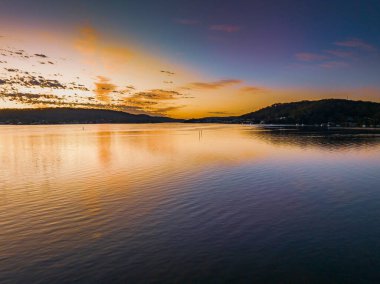 Körfezin üzerinde gökyüzünü boyayan altokümülüs bulutlarıyla birlikte havadan gün doğumu Central Coast, NSW, Avustralya 'da..