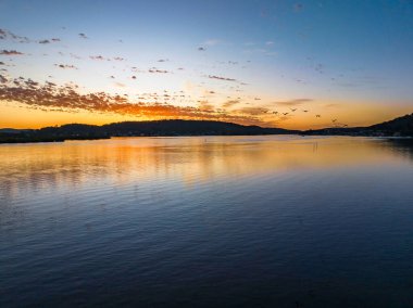 Körfezin üzerinde gökyüzünü boyayan altokümülüs bulutlarıyla birlikte havadan gün doğumu Central Coast, NSW, Avustralya 'da..