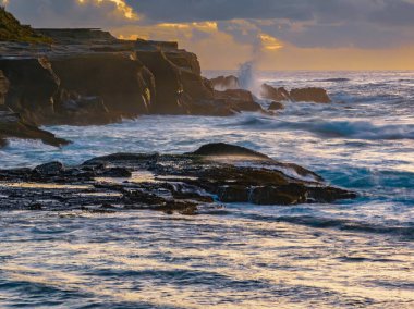 Aerial sunrise seascape with clouds at Spoon Bay in Wamberal on the Central Coast, NSW, Australia.