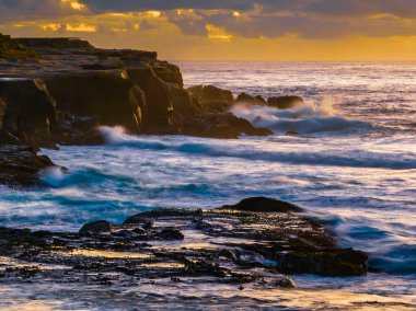 Aerial sunrise seascape with clouds at Spoon Bay in Wamberal on the Central Coast, NSW, Australia.