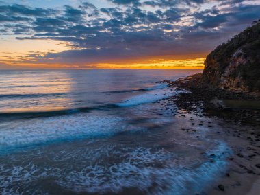 Aerial sunrise seascape with clouds at  Macmasters Beach on the Central Coast, NSW, Australia.