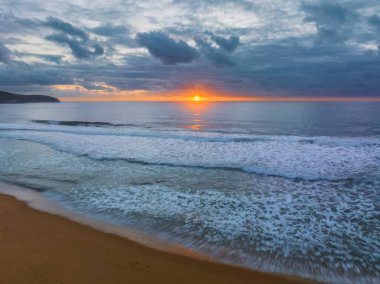 Sunrise seascape with colour and clouds at Killcare Beach on the Central Coast, NSW, Australia.