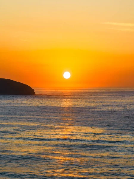 stock image Hazy sunrise seascape and some scattered high cloud at Killcare Beach on the Central Coast, NSW, Australia.