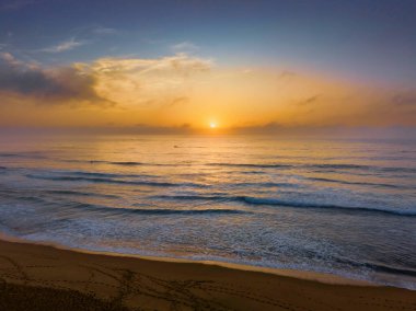 Aerial sunrise seascape with clouds, fog and haze at  Wamberal Beach on the Central Coast, NSW, Australia.