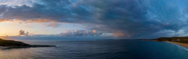 Sunrise with rain clouds at Putty Beach on the Central Coast, NSW, Australia.