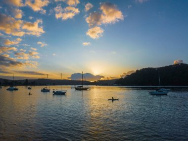Sunrise over Brisbane Water with clouds and boats at Ettalong Beach on the Central Coast, NSW, Australia.