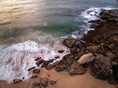 Central Coast, NSW, Avustralya 'daki Killcare Sahili' nde sörf ve kayalıklarla gün doğumu denizi..