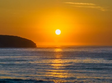 Central Coast, NSW, Avustralya 'daki Killcare Sahili' nde puslu gün doğumu deniz manzarası ve tam güneş..