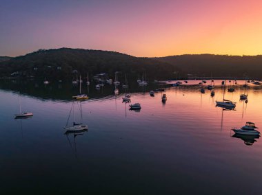 Gündoğumu, tekneler ve Hardys Körfezi 'nde bulutsuz bir gökyüzü Central Coast, NSW, Avustralya.