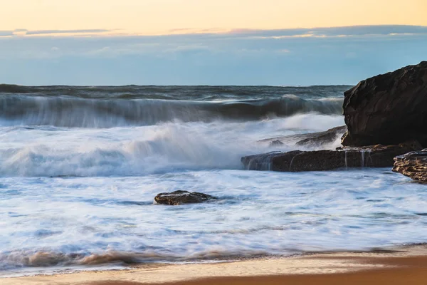 澳大利亚新南威尔士州中央海岸的Killcare海滩 有大浪冲到岸上的日出海景 图库照片