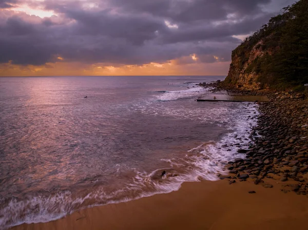 澳大利亚新南威尔士州中部海岸的麦克马斯特海滩 空中日出海景 多雨的云彩和小波浪 图库图片