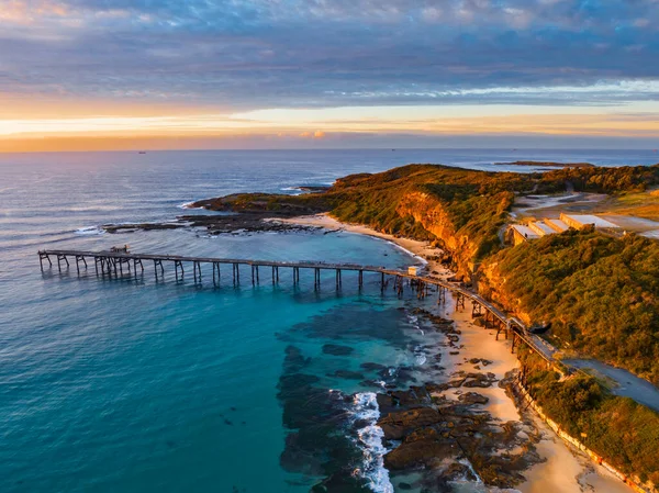 澳大利亚新南威尔士州中部海岸的凯萨琳山湾 阳光明媚 乌云密布的海景和堆满煤块的旧码头 免版税图库照片