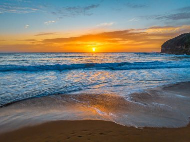 Central Coast, NSW, Avustralya 'daki Macmaster Sahili' nde güzel bulutlar ve dalgalarla hava gündoğumu..