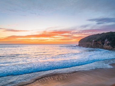 Central Coast, NSW, Avustralya 'daki Macmaster Sahili' nde güzel bulutlar ve dalgalarla hava gündoğumu..
