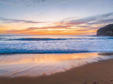Central Coast, NSW, Avustralya 'daki Macmaster Sahili' nde güzel bulutlar ve dalgalarla hava gündoğumu..