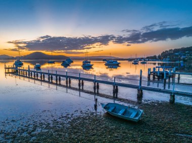 Brisbane 'de tekneli sakin bir gün doğumu. Bulutlar ve yansımalar Koolewong 'da Merkez Sahili, NSW, Avustralya.