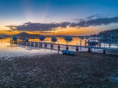 Brisbane 'de tekneli sakin bir gün doğumu. Bulutlar ve yansımalar Koolewong 'da Merkez Sahili, NSW, Avustralya.