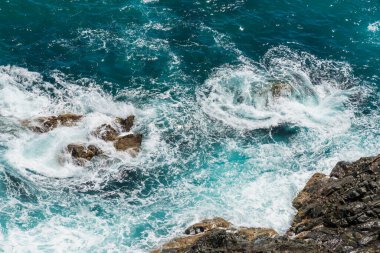 Beautiful sapphire blue ocean washing on the rocks at Bennett Heads Lookout on the Barrington Coast at Forster-Tuncurry, NSW, Australia clipart