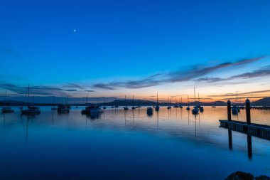 Gündoğumu, Brisbane 'deki teknelerle birlikte Central Coast, NSW, Avustralya' daki Koolewong 'da yansıyor..