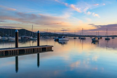 Gündoğumu, Brisbane 'deki teknelerle birlikte Central Coast, NSW, Avustralya' daki Koolewong 'da yansıyor..