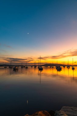 Gündoğumu, Brisbane 'deki teknelerle birlikte Central Coast, NSW, Avustralya' daki Koolewong 'da yansıyor..
