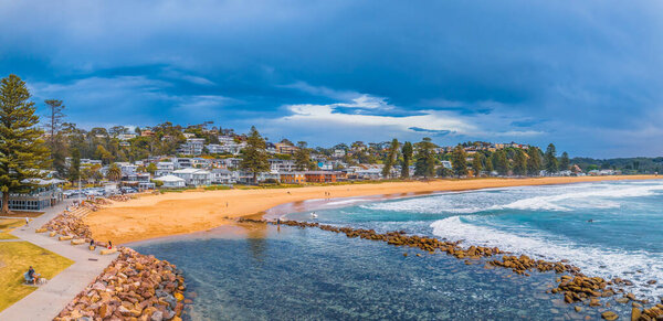 Мыс Санрайз с облаками и камнями на пляже Авока на Центральном побережье, Новый Южный Уэльс, Австралия.