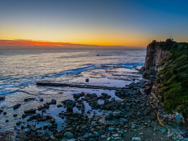 Aerial sunrise seascape with low cloud bank at The Skillion in Terrigal, NSW, Australia. clipart