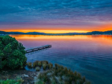 Körfezin üzerinde renkli hava gündoğumu, gökyüzü bulutlarla kaplı Woy Woy 'da Merkez Sahili, NSW, Avustralya.