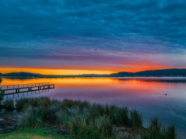 Körfezin üzerinde renkli hava gündoğumu, gökyüzü bulutlarla kaplı Woy Woy 'da Merkez Sahili, NSW, Avustralya.