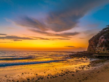 Yüksek bulut, deniz yosunu ve Avustralya 'nın merkez kıyısındaki Macmaster Sahili' nde küçük dalgalarla güzel bir hava gündoğumu..