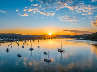 Central Coast, NSW, Avustralya 'daki Ettalong Sahili üzerinde karışık bulutlarla gün doğumu.