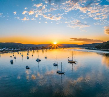 Central Coast, NSW, Avustralya 'daki Ettalong Sahili üzerinde karışık bulutlarla gün doğumu.