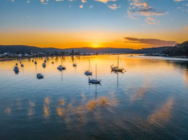 Central Coast, NSW, Avustralya 'daki Ettalong Sahili üzerinde karışık bulutlarla gün doğumu.