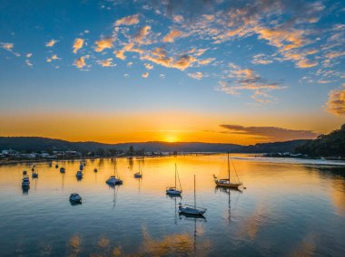 Central Coast, NSW, Avustralya 'daki Ettalong Sahili üzerinde karışık bulutlarla gün doğumu.