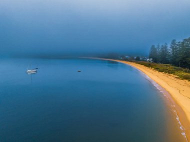 Avustralya, NSW 'nin merkez kıyısındaki Patonga Sahili' nde teknelerle Brisk Körfezi 'nde gün doğumu ve sis..