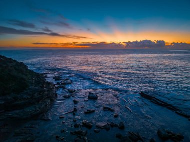 Terrigal, NSW, Avustralya 'daki The Skillion olarak bilinen kayalık körfezden havadan gün doğumu deniz manzarası.