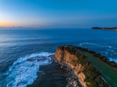 Terrigal, NSW, Avustralya 'daki The Skillion olarak bilinen kayalık körfezden havadan gün doğumu deniz manzarası.