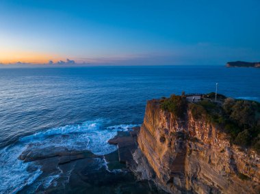 Terrigal, NSW, Avustralya 'daki The Skillion olarak bilinen kayalık körfezden havadan gün doğumu deniz manzarası.