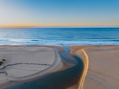 Gölün denize açıldığı havadan gün doğumu Central Coast, NSW, Avustralya 'daki Wamberal Sahili' nde..