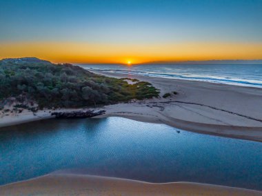 Gölün denize açıldığı havadan gün doğumu Central Coast, NSW, Avustralya 'daki Wamberal Sahili' nde..