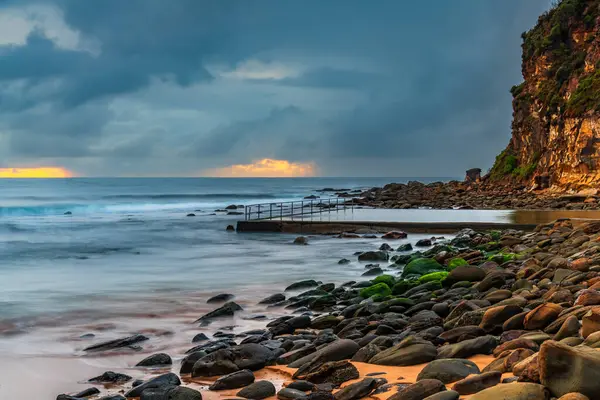 stock image Rainy day sunrise with overcast sky and small waves at  Macmasters Beach on the Central Coast, NSW, Australia.