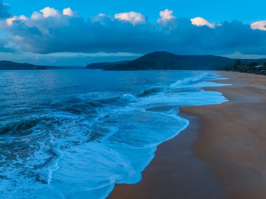 Deniz kıyısında hava güneşinin doğuşu, Avustralya, NSW 'deki Kuzey Pearl Sahili' nde alçak ve orta büyüklükteki bulut örtüsü arasında yağmur yağma ihtimalidir..