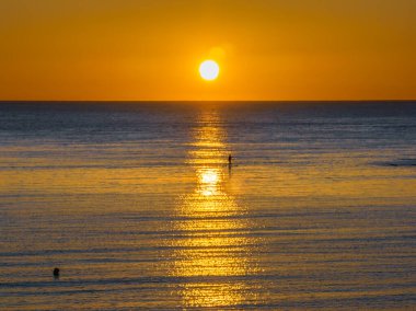Avustralya, NSW 'nin merkez kıyısındaki Toowoon Körfezi' nde açık bir gökyüzü ile okyanus üzerinde gün doğumu.