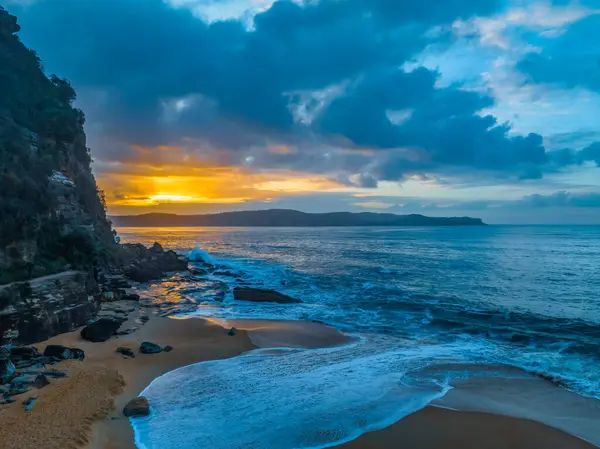 stock image Aerial sunrise at the seaside with a chance of rain amongst the low and medium cloud cover at North Pearl Beach on the Central Coast, NSW, Australia.