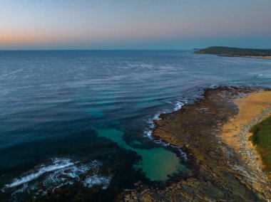 Avustralya, NSW 'nin merkez kıyısındaki Toowoon Körfezi' nde açık bir gökyüzü ile okyanus üzerinde gün doğumu.